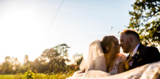 Bride-and-groom-sitting-on-grass